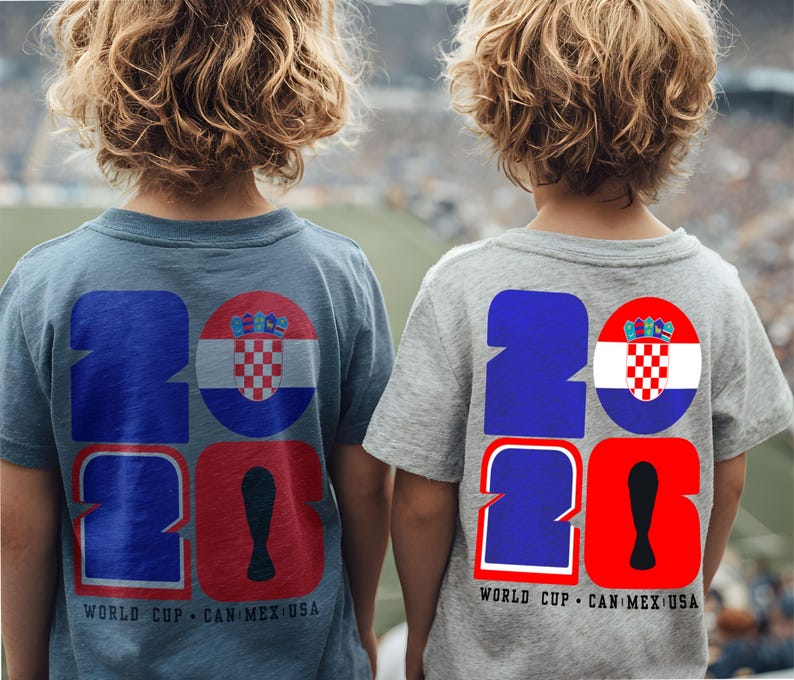 May include: Two children wearing blue and gray t-shirts with a large "2026" graphic on the back. The "2" is blue, the "0" is red, and a Croatian flag is in a circle. The text "WORLD CUP CAN MEX USA" is below.