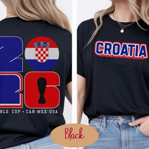 May include: Black t-shirts with Croatia-themed designs. One shirt features "CROATIA" in red and blue lettering. The other displays "2026" in blue and red, with a Croatian flag graphic and "WORLD CUP CAN MEX USA" text.