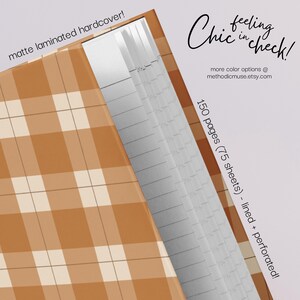 May include: A hardcover notebook with a matte laminated cover featuring a plaid pattern in shades of brown and cream. The notebook has 150 lined and perforated pages. Text on the cover reads "Chic feeling in check!"