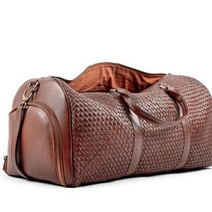 May include: A brown leather woven duffel bag with a zippered pocket and a top handle.