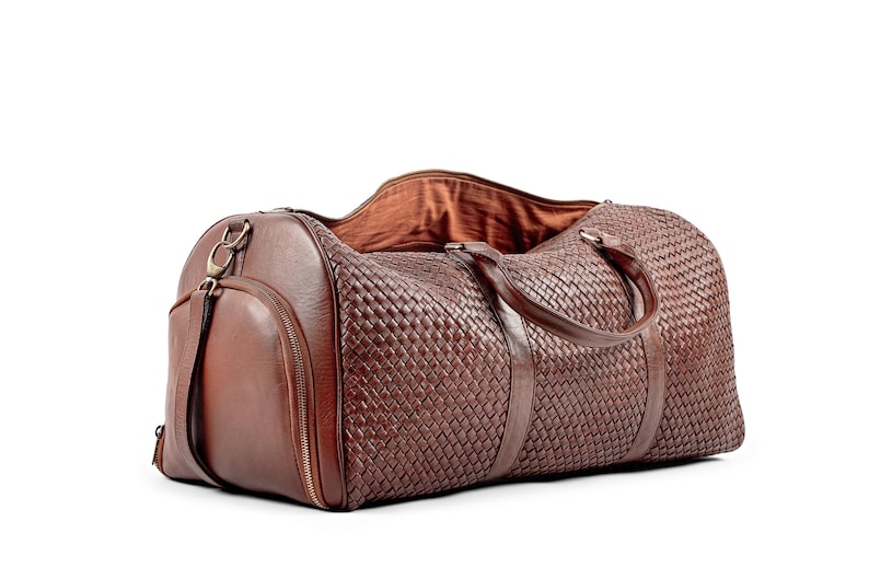 May include: A brown leather woven duffel bag with a zippered pocket and a top handle.