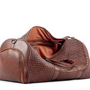 May include: A brown leather woven duffel bag with a zippered closure and a large pocket on the side.