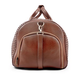 May include: A brown leather duffel bag with a woven pattern and a silver zipper. The bag has a top handle and a shoulder strap.