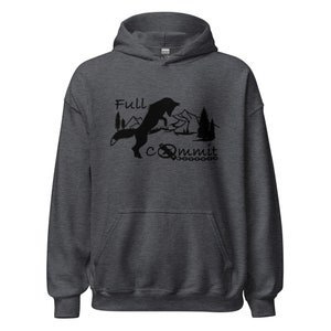 Op de afbeelding: Een donkergrijze hoodie met een zwart silhouet van een vos die over een bergketen springt. De tekst "Full Commit" staat onder de vos, met een kompas- en kettingontwerp.