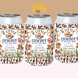 May include: Three white and silver can coolers with a brown and white cowhide pattern. Each cooler features a cowboy-themed design with the text "A Little Cowboy is on the Way" and "David's Baby Shower."