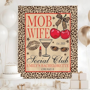 May include: A tan and brown leopard print banner with the words "MOB WIFE Social Club" in red script. The banner includes illustrations of cherries, lipstick, sunglasses, and a martini glass. The banner is for Emily's Bachelorette in Chicago, IL.
