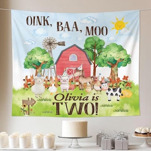 Pode incluir: Uma faixa de aniversário com tema de fazenda com o texto "OINK, BAA, MOO" e "Olivia tem DOIS!" apresenta um celeiro vermelho, um moinho de vento e animais de desenho animado. A faixa inclui uma ovelha, um porco, um cavalo, uma vaca e outros animais de fazenda. Um bolo e cupcakes estão em primeiro plano.
