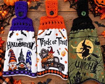 Peut inclure: Trois essuie-mains suspendus avec des hauts crochetés en violet, orange et noir. Les serviettes présentent des motifs d'Halloween : des gnomes avec le texte Happy Halloween, un camion avec Trick or Treat, et une sorcière avec The Witch.