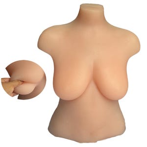 Puede incluir: Un torso de silicona color carne con busto y cintura pequeña y redondeada. Una imagen insertada muestra una nalga con un dedo insertado. El producto está diseñado para simular la parte superior del cuerpo.
