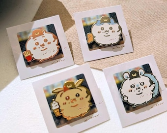 May include: Four enamel pins featuring cartoon characters with hats and accessories like fries and ice cream. Each pin is set in a white frame. The website miibrew.etsy.com is printed at the bottom.