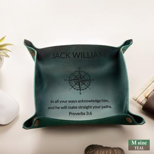 May include: Teal leather catchall tray with the name "JACK WILLIAM" and a compass rose design. The tray includes the Bible verse Proverbs 3:6. The tray is a medium size.