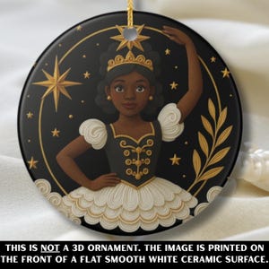 以下が含まれることがあります： 黒いセラミック製の丸いオーナメント。黒と金のドレスと白いチュチュを着たバレリーナが描かれています。デザインには金の星と金の星形が含まれています。下部のテキストは「これは3Dオーナメントではありません。画像は平らで滑らかな白いセラミック表面の前面に印刷されています」と書かれています。