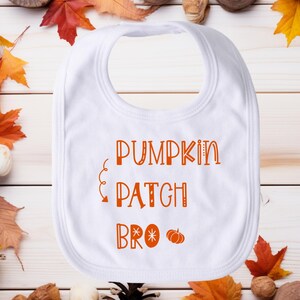 Puede incluir: Babero blanco para bebé con texto naranja que dice "Pumpkin Patch Bro" con un pequeño gráfico de calabaza naranja.