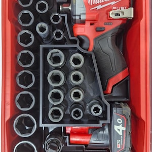 Könnte beinhalten: Ein rotes Milwaukee FUEL Schlagschrauber- und Steckschlüsselsatz in einem roten Koffer. Das Set enthält verschiedene Steckschlüssel und einen Akku. Der Schrauber ist schwarz und rot.