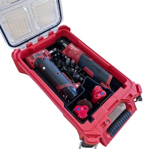 May include: Red Milwaukee Packout tool case with a clear lid. The case contains two red and black power tools, a battery, and various attachments.