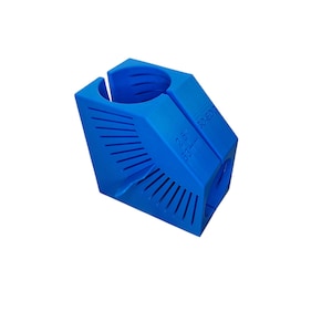 Puede incluir: Un objeto azul brillante impreso en 3D con una abertura cilíndrica y un diseño ranurado. El texto "2.5" y "39mm" es visible. El objeto tiene una forma geométrica con lados angulados y una serie de líneas paralelas.