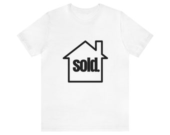 May include: White t-shirt with a black outline of a house with the word "sold" inside.