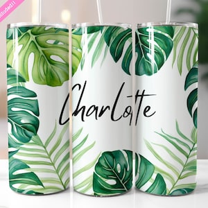 May include: Three stainless steel tumblers with a white background and a green tropical leaf pattern. The middle tumbler has the name "Charlotte" written in black cursive.
