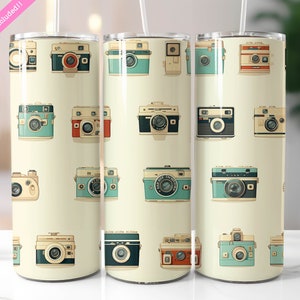 May include: Three stainless steel tumblers with a cream background and a repeating pattern of vintage cameras in various colors, including blue, red, and brown.