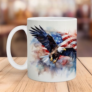 May include: White ceramic mug with a watercolor design of an American bald eagle flying in front of an American flag.