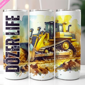 May include: A white tumbler featuring a yellow and black bulldozer illustration and the text "DOZER LIFE" in black. The bulldozer is set against a dirt background with watercolour splatters.