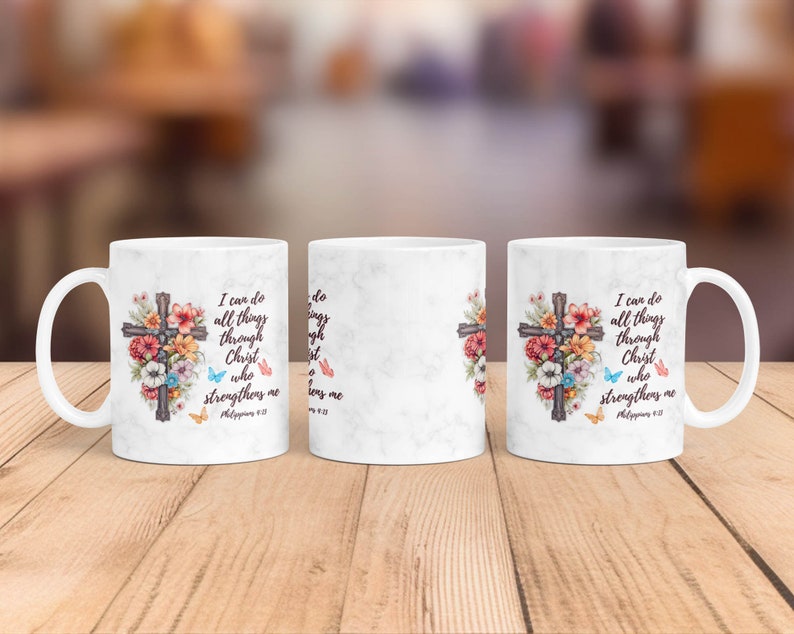 May include: White ceramic mug with a floral design and a cross. The mug has the text "I can do all things through Christ who strengthens me" and a Bible verse reference.
