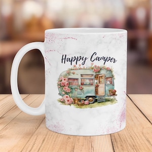 May include: White ceramic mug with a marble design and pink glitter accents. The mug features a watercolor illustration of a vintage camper van decorated with pink flowers and the text "Happy Camper".