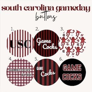 May include: A collection of six round buttons with various designs and text related to South Carolina Gamecocks. The buttons feature the text "USC", "Game Cocks", and "Gamecocks by 90!". The color scheme includes maroon, black, and white.