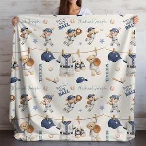 May include: A cream-colored blanket featuring a repeating pattern of teddy bears in baseball uniforms, baseballs, bats, gloves, and caps. The design includes clotheslines with jerseys and the text "Born to play BALL" and "Michael Joseph".