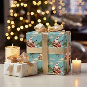 May include: Two gift boxes wrapped in blue and white patterned paper with a gold ribbon. The pattern features a cartoon Santa Claus playing a guitar on a beach. One box is smaller than the other.