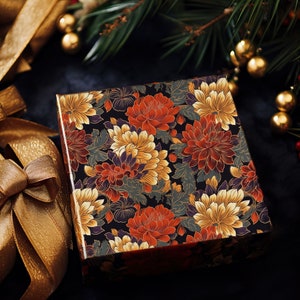 May include: A black gift box with a floral pattern featuring red, orange, yellow, and white chrysanthemums. The box is wrapped in a dark background with gold accents.
