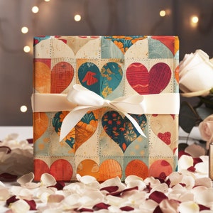 May include: A gift box wrapped in colorful patterned paper with a white ribbon. The paper features a patchwork design of hearts in various colors and patterns. The box is surrounded by white and red rose petals.
