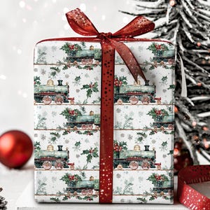 May include: A white gift wrap with a repeating pattern of green and red vintage train engines, holly, and snowflakes. A red ribbon with white polka dots is tied around the box.