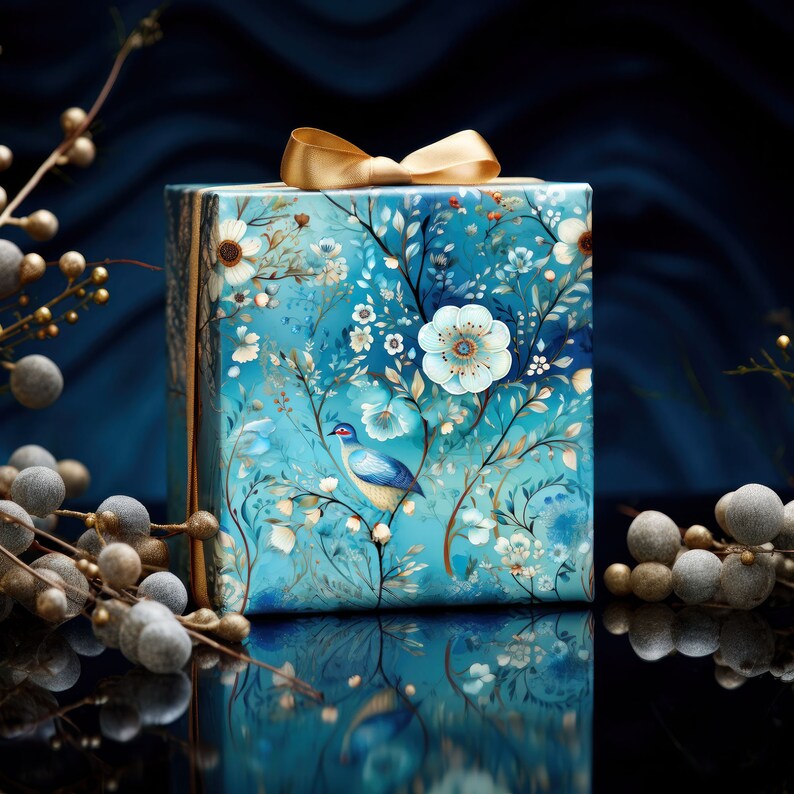 Pode incluir: Uma caixa de presente azul com uma fita dourada e um design floral. A caixa apresenta um pequeno p&aacute;ssaro azul em um galho.