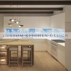 May include: A kitchen featuring white cabinetry, a light wood island with integrated shelving, and two wooden stools. Above the island hang four pendant lights. A horizontal window displays a blue sky. The text CUSTOM KITCHEN DESIGN is centered.