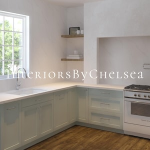 May include: A kitchen with white countertops and light green cabinets. The kitchen features a white farmhouse sink, a stainless steel faucet, and a white range with a black stovetop. There are two shelves above the countertop on the left side of the image, and a large white tiled area above the range on the right side of the image. The text "Interiors By Chelsea" is visible in the image.