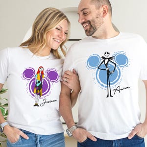 A smiling couple wearing white t-shirts with characters from the movie " jack Skellington" printed on them.