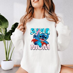 a woman wearing a sweatshirt that says super mom