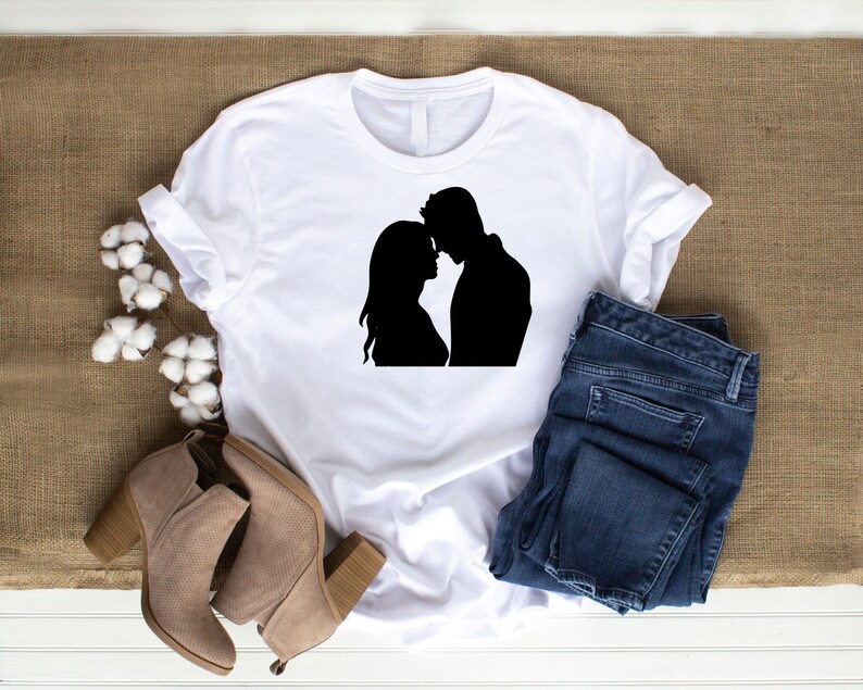 May include: White t-shirt with a black silhouette of a couple embracing.