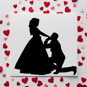 May include: A black silhouette of a couple on a white background. The woman is wearing a long dress and the man is kneeling on one knee. The image is surrounded by pink and red hearts.