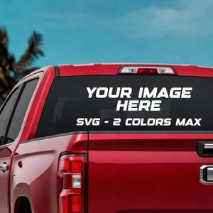 May include: Red pickup truck with a white decal on the rear window. The decal reads "YOUR IMAGE HERE" above "SVG - 2 COLORS MAX". The sky is blue with a few palm trees in the background.