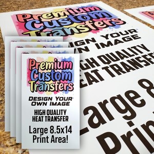 May include: A stack of white paper sheets with the text "Premium Custom Transfers" in colorful lettering. The text "Design Your Own Image," "High Quality Heat Transfer," and "Large 8.5x14 Print Area!" are also visible.