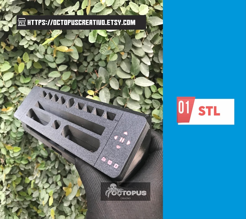 May include: A black 3D-printed organizer with various compartments and pink button details. The organizer is held against a backdrop of green foliage. The text "01 STL" is displayed on a white and red rectangle.