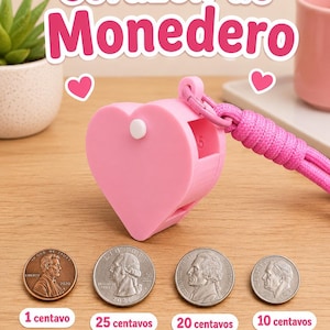 Puede incluir: Un dispensador de monedas de plástico rosa claro en forma de corazón con un cordón de paracord rosa a juego. El dispositivo tiene un pequeño botón blanco en el lateral y el número 5 en relieve. Debajo se muestran cuatro monedas de EE. UU.