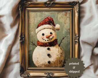 May include: A framed painting of a snowman with a red hat and scarf. The snowman is painted in a textured style, giving it a rustic look. The background is a muted green.