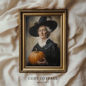 May include: A framed painting of a woman wearing a black witch hat and holding a pumpkin. The woman is wearing a black dress with a white lace collar. The painting is set against a neutral background.