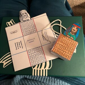 Peut inclure: Un artisanat en papier fait &agrave; la main repr&eacute;sentant une sc&egrave;ne biblique. L'artisanat pr&eacute;sente un panier et des personnages avec des visages illustr&eacute;s. Le texte sur le papier se lit "Conversion is changing one thing into another" et "Read about Paul Conversion in Acts 9."