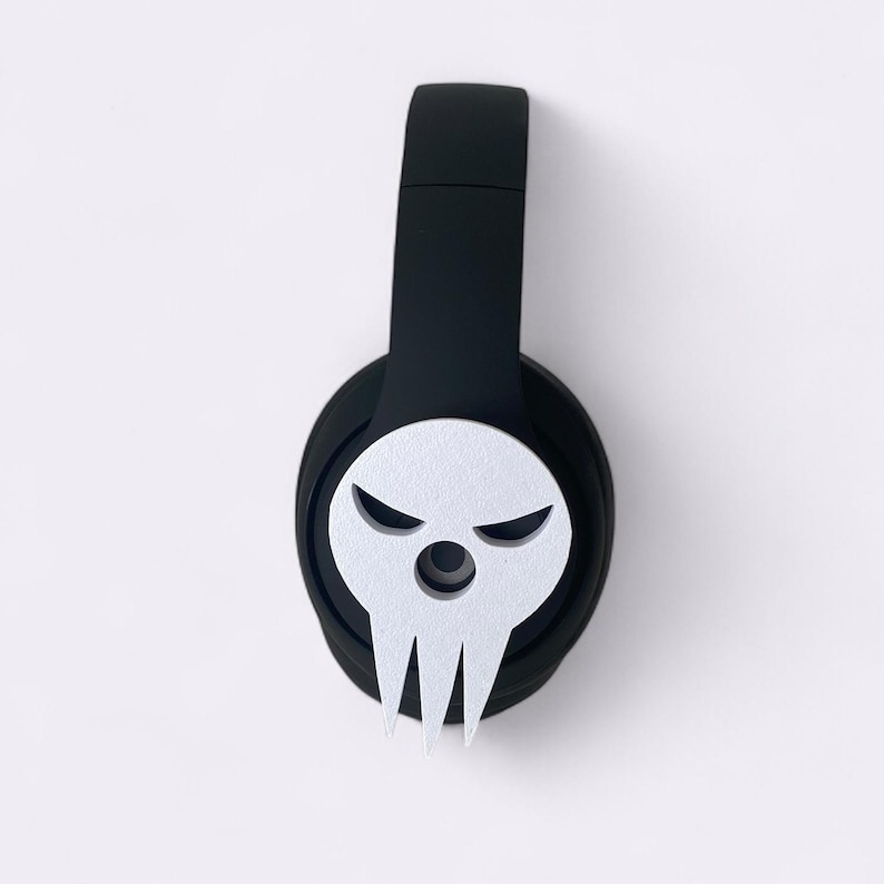 Peut inclure: Casque audio noir avec un motif de cr&acirc;ne blanc sur l'&eacute;couteur. Le cr&acirc;ne affiche une expression mena&ccedil;ante avec des sourcils anguleux et une m&acirc;choire pointue. Le casque a un bandeau rembourr&eacute;.