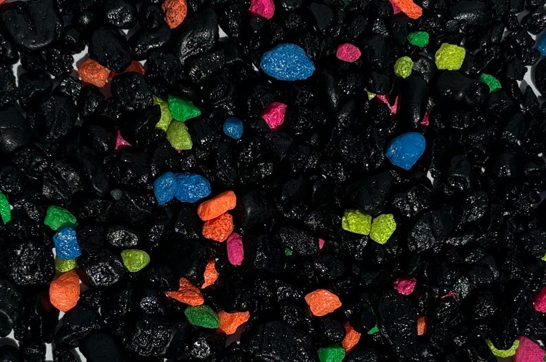 May include: Black lava rock aquarium gravel with colorful accents. The gravel is a mix of black, blue, green, orange, and pink.