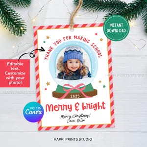 Könnte beinhalten: Ein weihnachtliches Geschenk-Etikett mit einem Foto eines Kindes in einem Schneekugel-Design. Das Etikett hat einen rot-rosa gestreiften Rand, mit dem Text "Thank you for making school" und "Merry & bright". Enthält den Text "Merry Christmas! Love, Ellie."